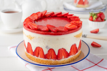 Fraisier mousse cake. Strawberry cake with biscuit, mousse and jelly on a white wooden background. Summer dessert. Selective focus. Copy space.