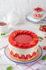 Fraisier mousse cake. Strawberry cake with biscuit, mousse and jelly on a white wooden background. Summer dessert. Selective focus. Copy space.