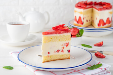 Fraisier mousse cake. Strawberry cake with biscuit, mousse and jelly on a white wooden background. Summer dessert. Selective focus. Copy space.
