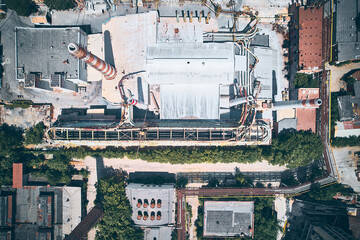 Chimneys and pipelines of inactive plant. Top down aerial view of obsolete factory