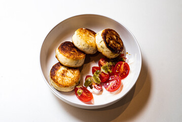 Cheesecakes with jam in a plate on a white background