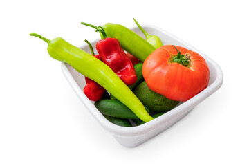 Washed vegetables with drops of water in a bowl are waiting for slicing into a salad, isolated on white