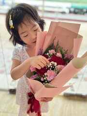 beautiful cute little girl holds flower bouquets in her hand
