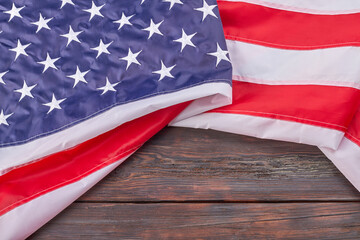 Close-up large fabric United States flag on wood. USA banner with stripes and stars.
