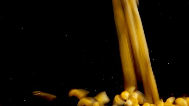 Falling popcorn mais grains on a black background. Slow motion.
