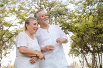Fototapeta premium Portrait of a lovely elderly couple having fun in the garden. concept of life after retirement Asian couple in the park in the morning. A happy man and a senior woman. happiness concept