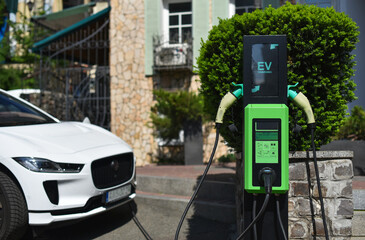 electric vehicle charging station with connected crossover on background