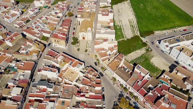 unique drone wide angle overthe top shoot of a wonderful white town of Cadiz, Spain with its colored roofs and the green summer fields with vineyards and different green, yellow and red colors