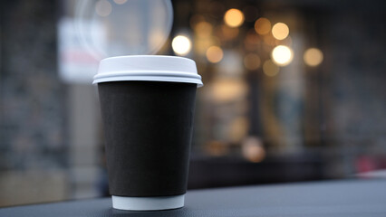 A takeout coffee cup and a bokeh effect. Coffee in a recycle paper cup