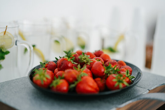 Fresh Strawberry closeup on black plate and stone table blur background