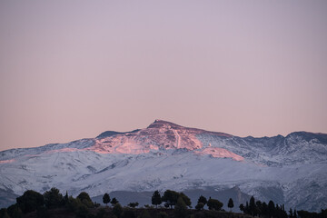 snowy landscape of moulhacen mountain at sunset