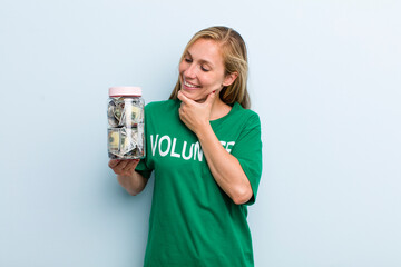 young adult blonde woman smiling with a happy, confident expression with hand on chin. volunteer...