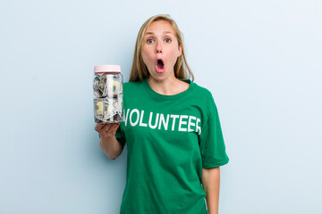 young adult blonde woman looking very shocked or surprised. volunteer and donation concept