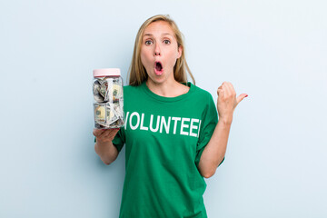 young adult blonde woman looking astonished in disbelief. volunteer and donation concept