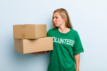 young adult blonde woman feeling sad, upset or angry and looking to the side. volunteer and...
