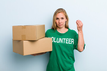 young adult blonde woman making capice or money gesture, telling you to pay. volunteer and donation...