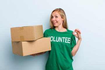 young adult blonde woman looking arrogant, successful, positive and proud. volunteer and donation...