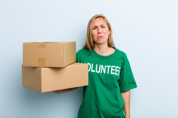 young adult blonde woman feeling sad and whiney with an unhappy look and crying. volunteer and...