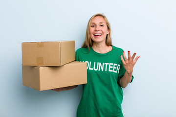 young adult blonde woman feeling happy, surprised realizing a solution or idea. volunteer and...
