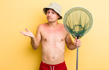 young handsome guy feeling puzzled and confused and doubting. fisher in holidays with a net