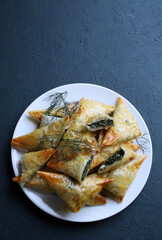 Cucina tradizionale greca. Spanakopita, triangoli  croccanti di pasta fillo con spinaci e feta....