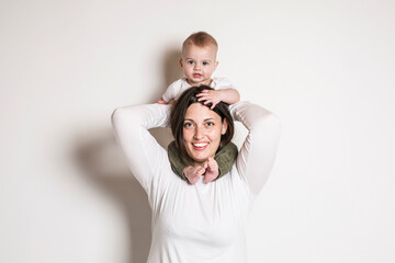 Cheerful baby boy toddler with his mother on white studio background