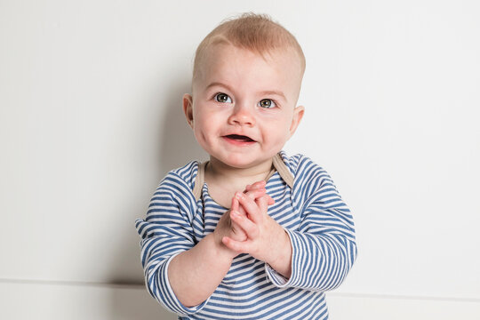 Cheerful baby boy toddler on white studio background