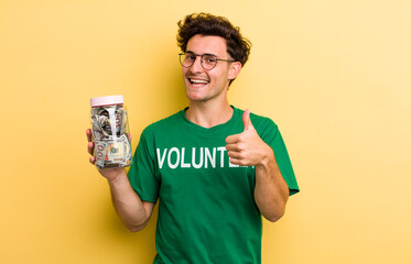 young handsome guy feeling proud,smiling positively with thumbs up. donation and volunteer concept