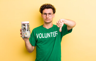 young handsome guy feeling cross,showing thumbs down. donation and volunteer concept