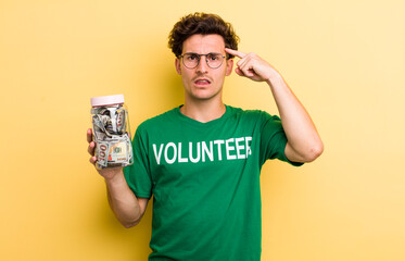 young handsome guy feeling confused and puzzled, showing you are insane. donation and volunteer...