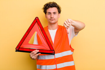 young handsome guy feeling cross,showing thumbs down. car emergency triangle concept