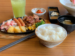 Various menus, sushi, sashimi, nigiri, pan fried pork and miso soup. Sashimi, chutoro sashimi, Japanese food chopsticks and wasabi on the black table, Japanese food style. blurs focus.