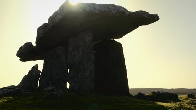 A backlit Dolmen in Ireland as the sun slowly rises over the top of the Dolmen