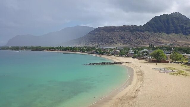 Rising aerial view of Waianae's Pokai bay on a calm and sunny day