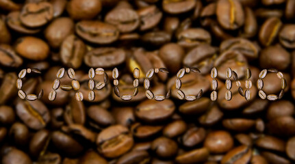 The word Cappuccino made from coffee beans on the background of coffee