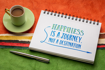 Happiness is a journey, not a destination, inspirational note - handwriting in a notebook with a cup of coffee against abstract paper landscape, personal development concept