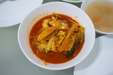 Home cook fish curry on white bowl on glass table