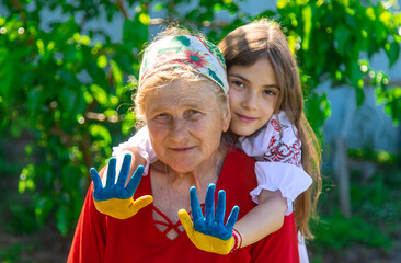 Child and grandmother hand drawn flag of Ukraine. Selective focus.