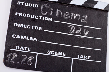 Obraz premium 28 december world cinema day. Close-up cinema clapperboard. Chalk handwriting of 12.28 date .
