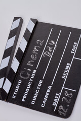 Close-up vertical shot black cinema clapboard with chalk handwriting. Isolated on white background.