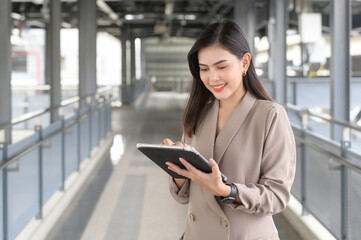 A young beautiful businesswoman is using tablet in Modern city , business technology , city lifestyle concept