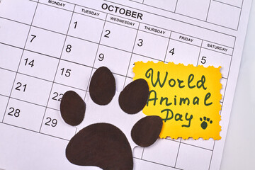 World animal day handwriting. Animal footprint on the calendar. Top view flat lay.