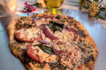 .Top view of vegetarian pesto pizza on pizza peel.