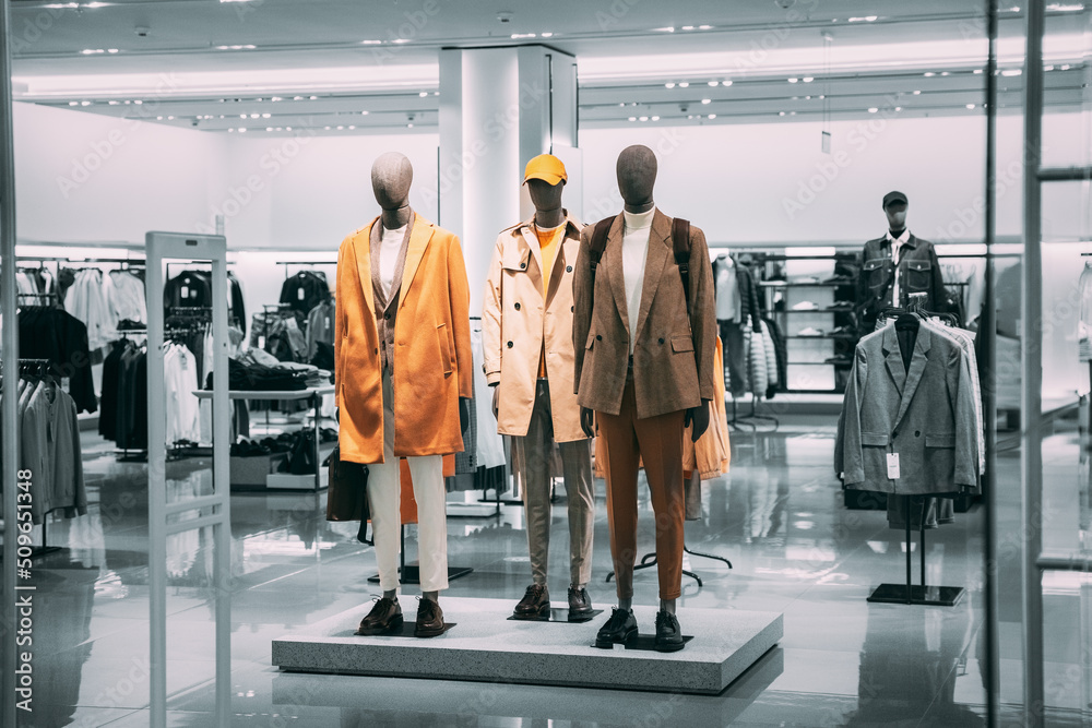 Wall mural Mannequins Dressed In Men male Casual Clothes And coat jackets Clothes In Store Of Shopping Center. Stack clothes In Store Of Shopping Center. shelf display in shop mall store. Store Of Shopping - Wall murals