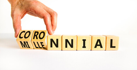 Millennial or coronnial symbol. Doctor turns wooden cubes and changes the concept word Millennial to Coronnial. Beautiful white table white background. Millennial or coronnial concept. Copy space.