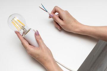 woman holding in her hands a cartridge with an electric lamp