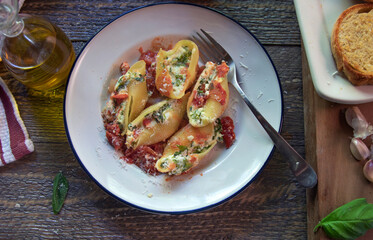 Top view of stuffed jumbo shells on a natural wood surface