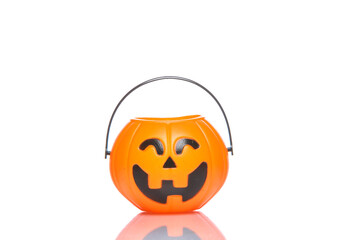 Halloween candy bucket with jack pumpkin face isolated on white background with reflection