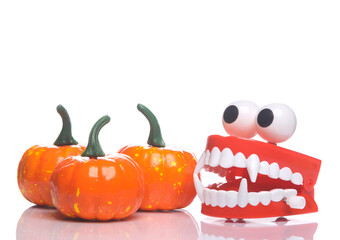 Clockwork jaws with monster fangs and pumpkin isolated on white background with reflection. Halloween decor