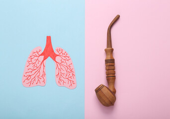 Harm of smoking on lung health concept. Anatomical lungs and smoking pipe on a blue-pink pastel background